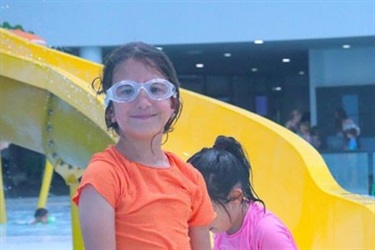 Picture of two young children enjoying water slides at aquatic centre