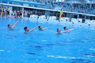 Image of group of synchronised swimmers in formation in the pool
