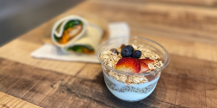 A chia pudding with berries and a chicken wrap with spinach
