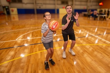 training older child to take a basketball shot