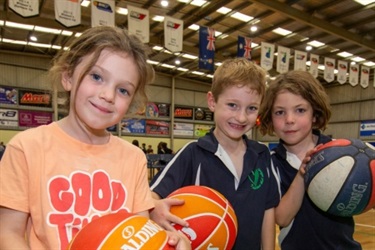 older kids posing with basketballs