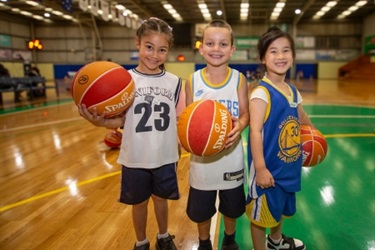 older kids posing on a basketball court