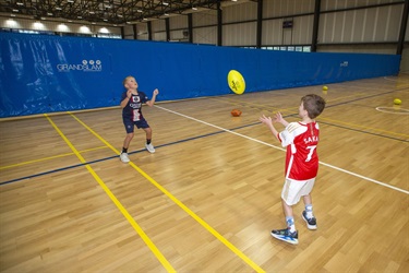Two children catch each others handballing during the multi-sports school holiday program
