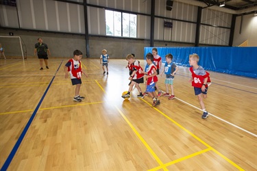 Group of young kids play futsal in teams