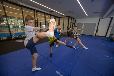 Group of children practise their high kicks