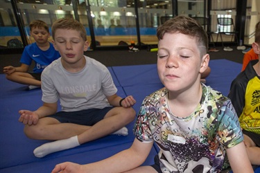 Group of children learn to relax and visualise after their karate session