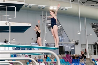 Two divers about to leap off the diving boards