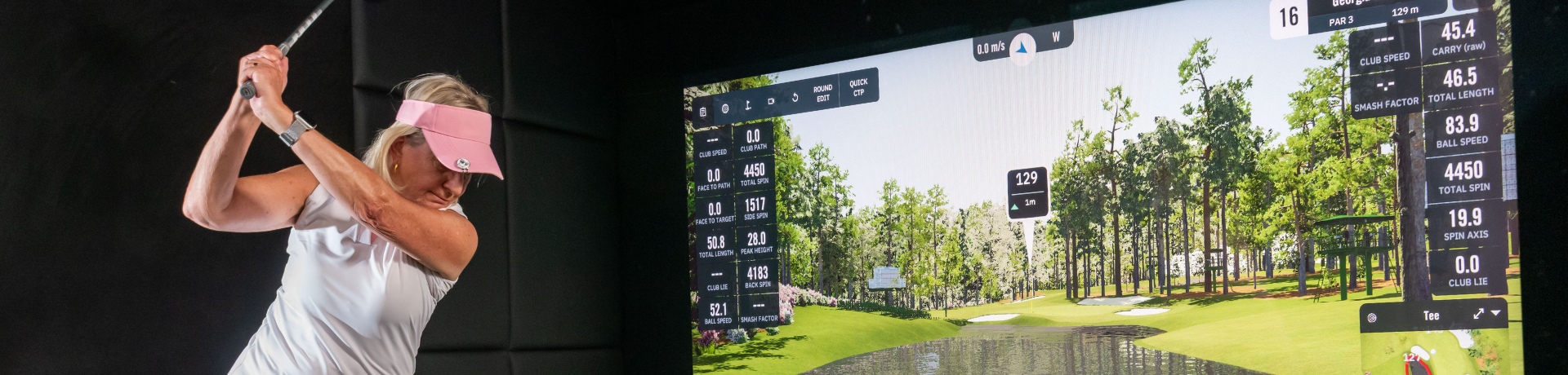 Person prepares to swing while standing in front of the golf simulator