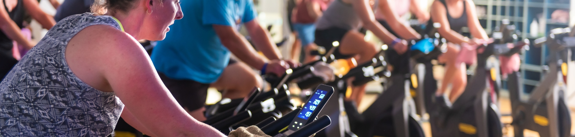 group of people on exercise bikes in a group fitness class looking